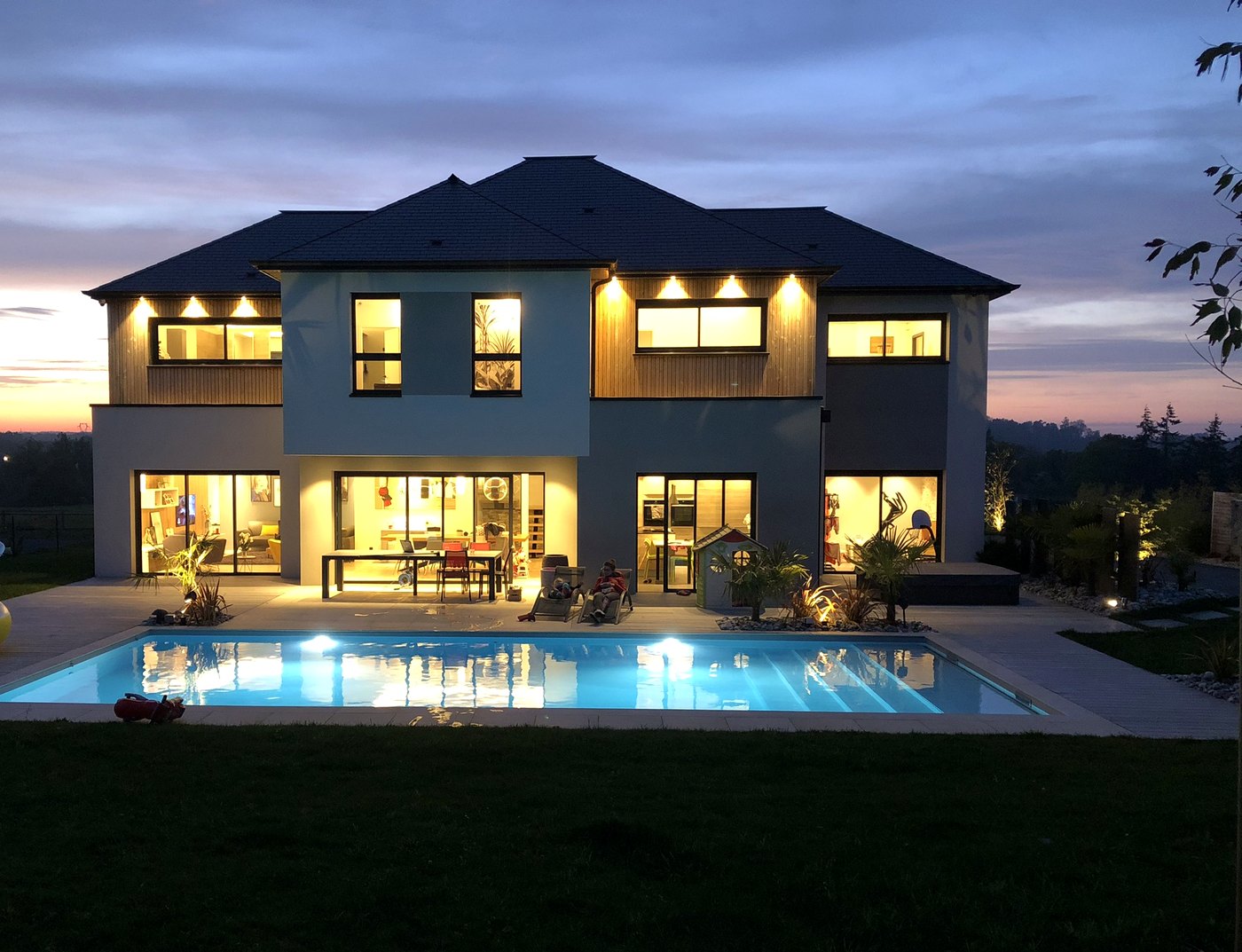 Façade au crépuscule, piscine illuminée